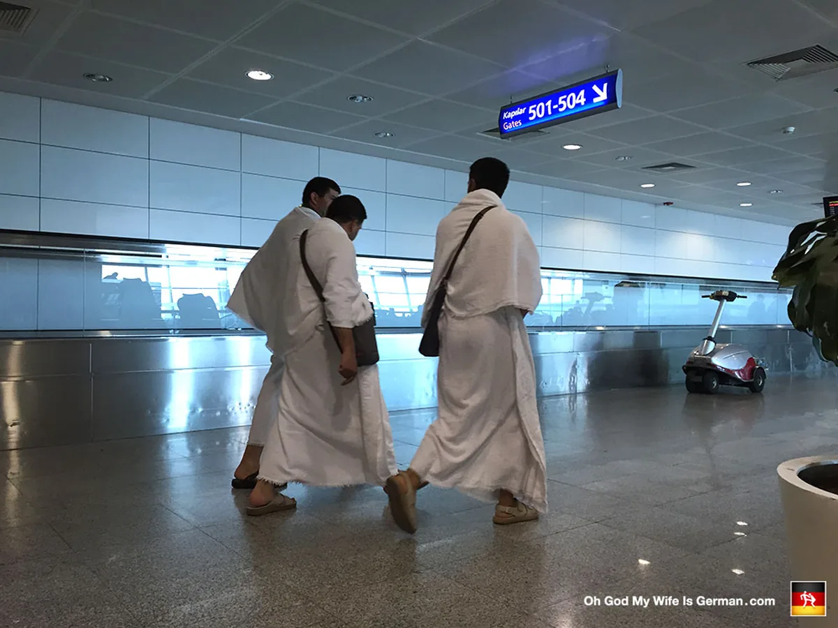 Pèlerin en tenue d'ihram blanche dans un aéroport avant un vol vers Médine ou La Mecque