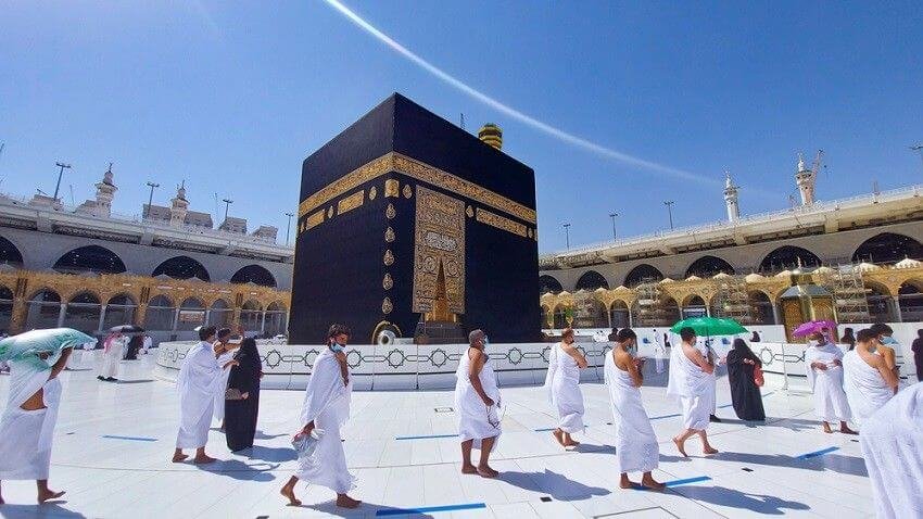 Pèlerins en ihram effectuant le Tawaf pieds nus autour de la Kaaba
